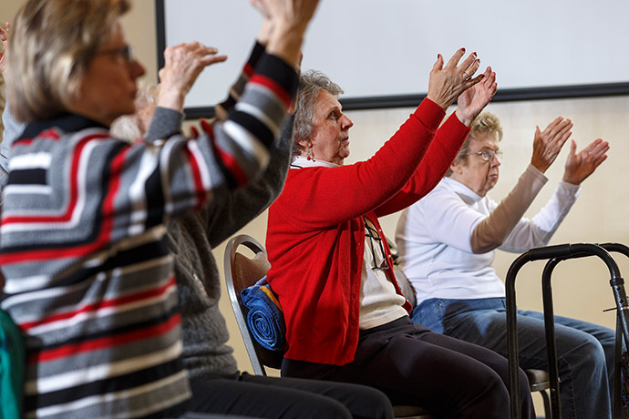 Martha Armstrong, left, Sandy Irving, center, and Phyllis Agner hold a seated pose.