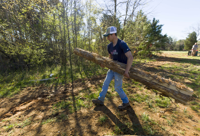 Farm manager Zeke Overbaugh helps build deer fencing at the farm. “I’m excited about this project because it means it’s becoming normal for towns and citizens to think about urban farming,” he says.