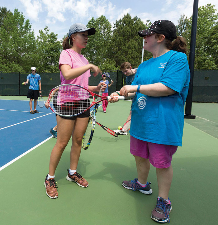 Western Wake Tennis Association volunteer Ava Autry, left, shares some tennis tips with Lisa Deprisco during an Abilities Clinic at Cary Tennis Park.